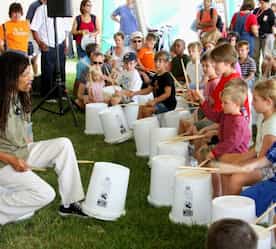 a performer teaching kids how to make music at the festival