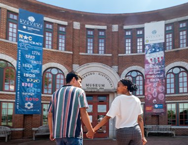 Two people walking into the museum