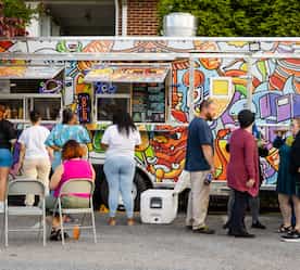 people lined up in front of food truck placing orders