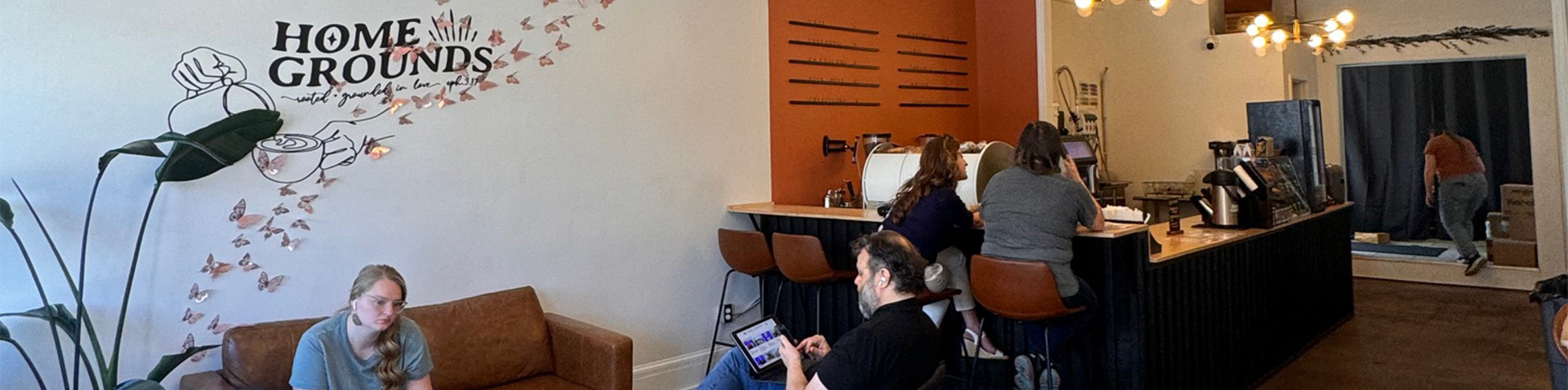 a student doing work in coffee shop and other ladies enjoying talking with each other 