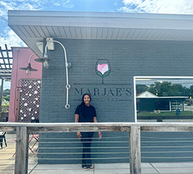 owner in front of exterior sign