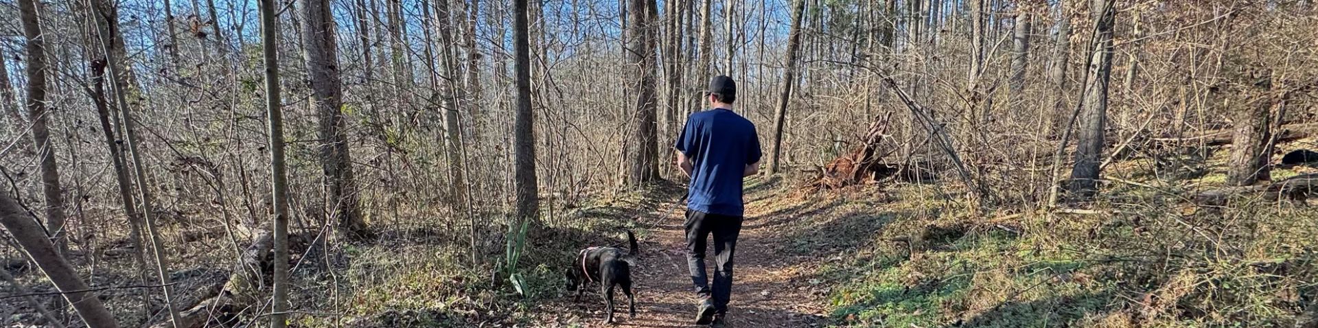 a man walking his dog on the trail