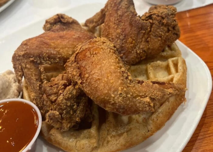 fried chicken on a waffle with sauce cup