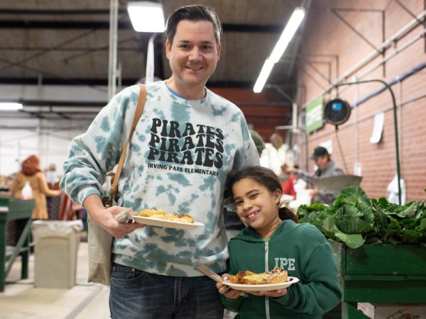 man and daughter holding plates of food