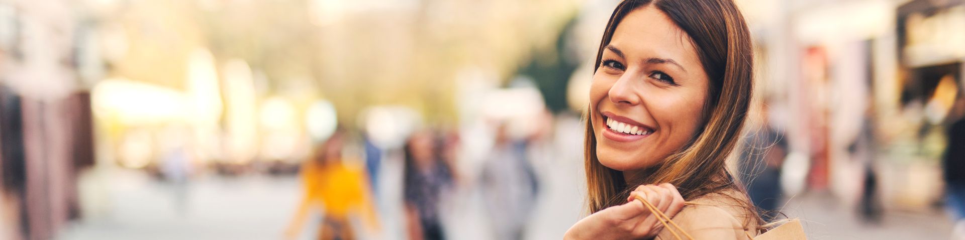 a girl holding a shopping back and smiling
