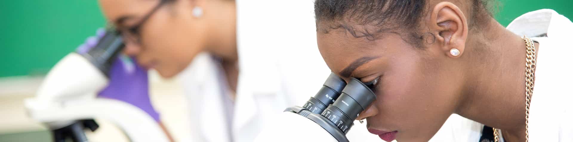 two girls looking through a microscope 